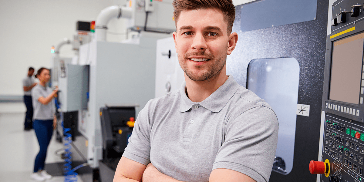 operador de maquinaria en frente de maquina para programación cnc