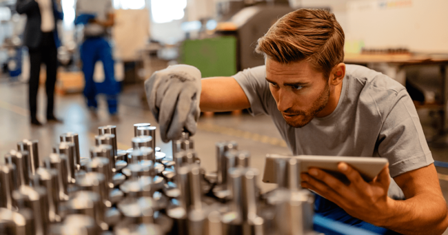 persona inspeccionando la calidad de las piezas fabricadas por medio de cnc en un taller de maquinado